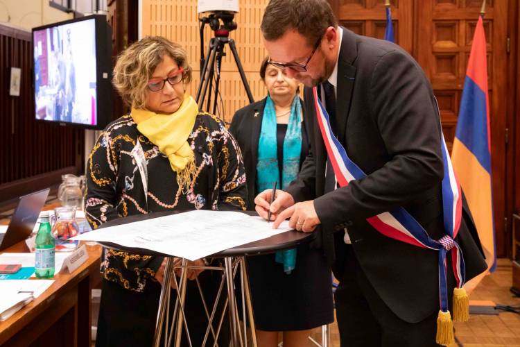 Le maire Cédric Van Styvendael signant le document du parrainage.
