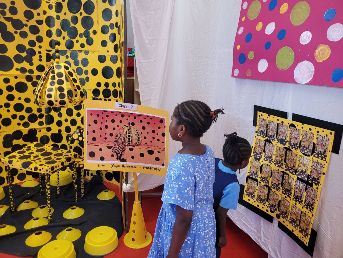 Les enfants observent les photos prises d'eux avec leurs déguisements dans l'oeuvre de Yayoi Kusama.