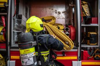 pompier de la caserne de cusset en train de charger une lance à incendie dans un camion