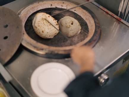 Une cuisson traditionnelle sur les parois du four pour les pains naans.