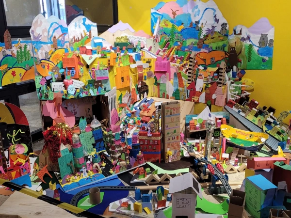 Une maquette de ville fabriquée par des enfants avec des immeubles en papier coloriés au feutre