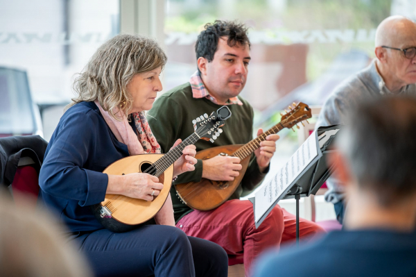 Deux musiciens jouent de la mandoline dans la salle de la résidence séniors Château-Gaillard